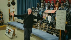 David Thatcher standing in the Watanabe Art Museum, Tottori, surrounded by Japanese samurai armour